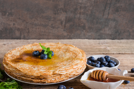 stack of pancakes with fresh blueberries, mint and honey for breakfast. close upの写真素材
