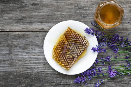 Honey with lavender flowers and honeycombs on rustic wooden table. healthy food. top view
