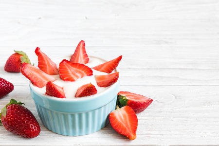 healthy strawberry yogurt with fresh berries over white wooden table. healthy breakfast. close up with copy spaceの写真素材