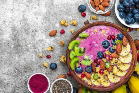 Healthy breakfast. acai smoothie bowl with blueberry, fruits, granola, almonds, pumpkin and chia seeds. detox food concept. top view with copy spaceの写真素材