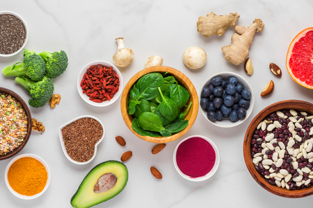 Superfoods on white marble table. vegetables, acai, turmeric, fruits, berries, nuts and seeds. Healthy vegan food top viewの写真素材
