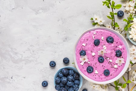 Smoothie bowl with fresh berries, cottage cheese, chia seeds and flowers for healthy vegan vegetarian diet breakfast. top viewの写真素材