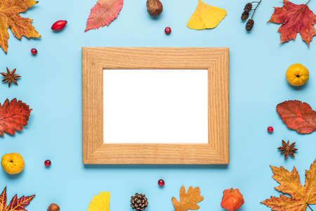 Thanksgiving autumn photo frame. Dried leaves, flowers, nuts, berries on blue background. Flat lay, mock up. top view with copy spaceの写真素材