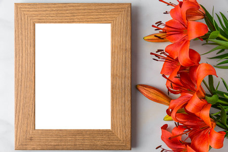Blank photo frame with orange lily flowers on white background. Mock up. Flat lay. Wedding or Mothers dayの写真素材