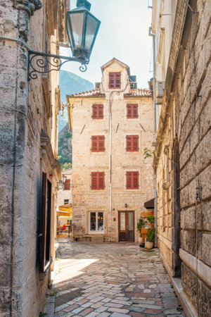 Medieval narrow street in Kotor town, Montenegro on Adriatic sea in sunny day. Vertical orientation. Popular summer vacation destinationの写真素材