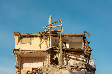 Destroyed residental building. Upper floors of destroyed house with broken apartments and a pile of construction debris. Buildings damaged by terrorist attack, war or earthquakeの写真素材