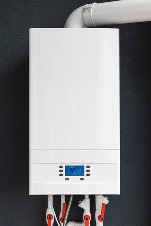 Gas boiler for winter home heating and water heating installed on the balcony of modern house for energy savings and economy. Vertical orientationの写真素材