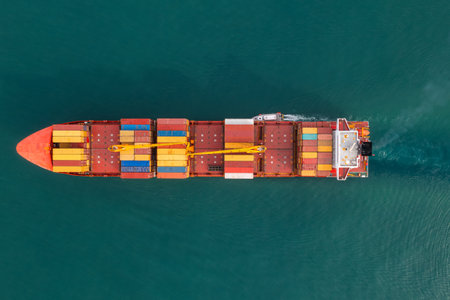 Aerial view of cargo container ship carrying containers for import and export, business logistic and transportation in open sea. Top downn drone view. Freight shippingの写真素材