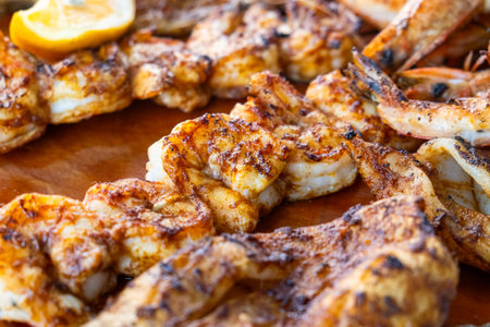 Grilled shrimps on seafood wooden plate. Close up of charcuterie platter board with shrimp, fish, squids and octopus in fish restaurant. Close up. Healthy diet foodの写真素材