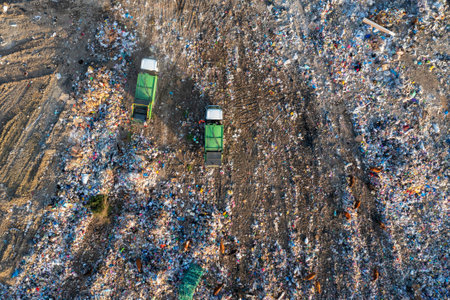 Aerial view of garbage truck unload pile of waste at landfill with cows. Dump of unsorted waste garbage pile in trash dump. Environmental pollution and ecological disaster. View from droneの写真素材