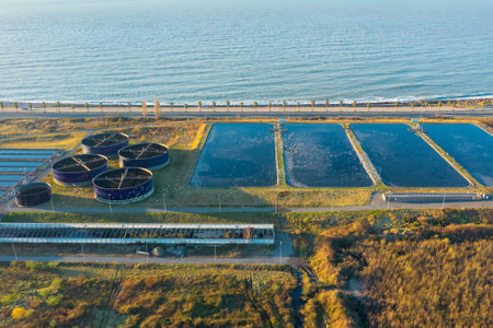 neAerial view of modern sewage treatment plant by the sea. Industrial water treatment with round...