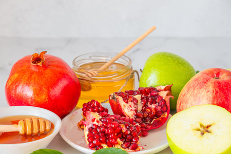 Jewish New Year holiday Rosh Hashana background with honey, pomegranate and apples on white backgroundの写真素材