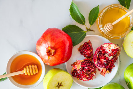 Rosh Hashana Jewish New Year holiday background with honey, pomegranate and apples on white marble background. flat lay. top view with copy spaceの写真素材