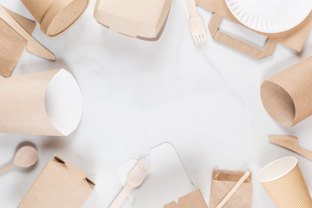 Frame made of eco-friendly, biodegradable disposable tableware and cutlery made of paper and wood. Cups, bags, cutlery and containers for sustainable and environmentally food service. Flat lay.の写真素材