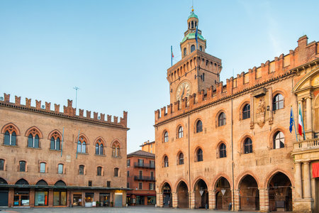 Bologna old town with Palazzo dAccursio on Piazza Maggiore, Emilia Romagna, Italy. Town Hall with big clock on tower on main city square at sunrise with nobody. Travel destination in Europeの写真素材