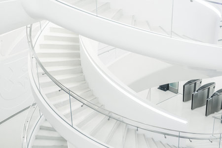 Minimalistic white spiral staircase with smooth curves and geometric patterns in The Museum of the...