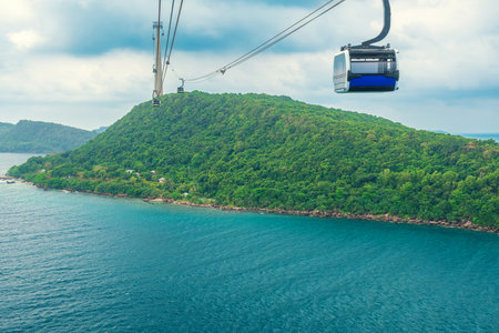 Cable car gondola gliding over turquoise sea and green tropical island. Longest Hon Thom cable car ride in the world on Phu Quoc island, Vietnam. Modern tourism technology and infrastructureの写真素材
