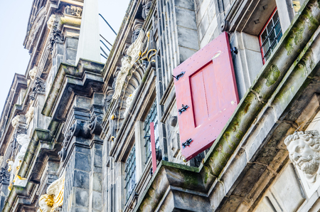 Detail of Delft city hall building with the red shutters and sculptures on the exrterior, Delft, Netherlandsの写真素材