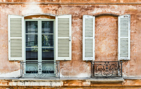 Two old shutters on a window and a wall built to mask a window  Decoration on old Franch building の写真素材