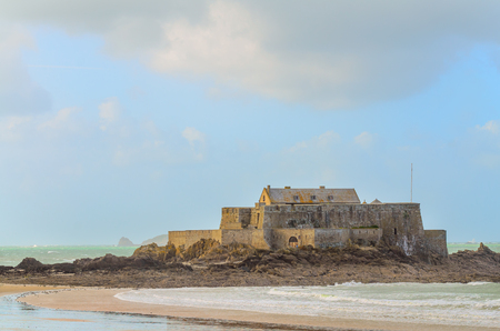 Fort National fortress in St-Malo, France, on windy weather and high tide, with greenish water reflections and waves.のeditorial素材