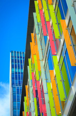 Modern building with multicolored windows and design panels attached in Amsterdam Netherlands vertical positionの写真素材