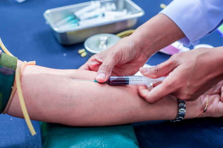 Nurse preparing a syringe for an injection to a patient.の写真素材