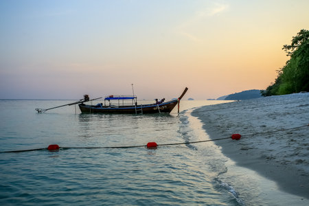 Fishing boat on the beach at sunrise, Krabi, Thailandの写真素材