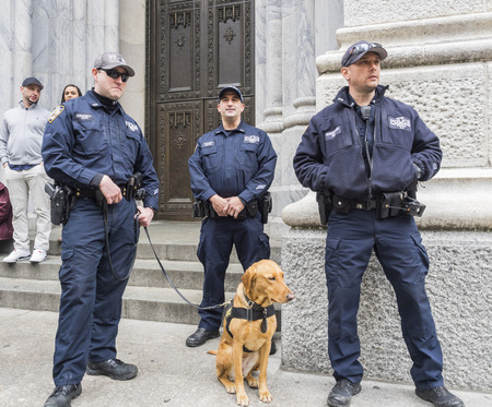 New York, NY, USA - April 1, 2018: Police officers with dog protect people at 2018 New York Easter Parade and Bonnet Festival on 5th Avenue, Manhattan near St.Patrickâs Cathedral.のeditorial素材