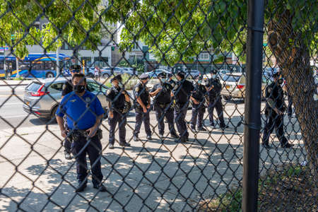 Brooklyn, NY, USA - August 1, 2020: TPolice officers watch They canât Burn Us All - unity rally against hate crimeand racism after an 89 year old Asian woman was a victim of a hate crime in Bensonhurstのeditorial素材