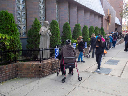 Brooklyn, NY, USA - October 27, 2020: People waiting in line for early general voting at St. Dominic's Catholic Church, Brooklyn amid coronavirus pandemic.のeditorial素材
