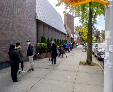 Brooklyn, NY, USA - October 27, 2020: People waiting in line for early general voting at St. Dominic's Catholic Church, Brooklyn amid coronavirus pandemic.のeditorial素材