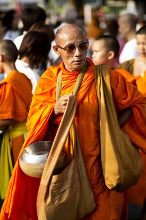 BANGKOK , THAILAND - MARCH 17: People Gives food offerings to a Buddhist monk on March 17, 2012 in Bangkok, Thailand. Thai traditional, people will make merit making by give food to monkのeditorial素材