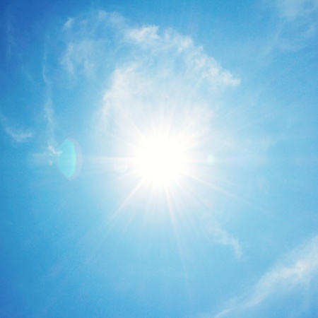 The sun shines bright in the daytime in summer. Blue sky and clouds.
