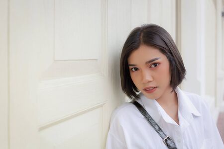 Portrait of a beautiful woman alone standing in front of the wallの写真素材