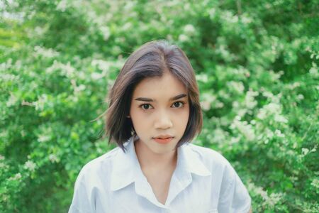 Portrait of an Asian woman in a garden full of leavesの写真素材