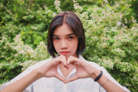 Portrait of an Asian woman in a garden full of leavesの写真素材