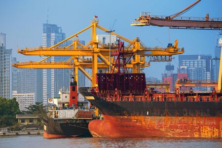 Container ship in export and import business and logistics. Shipping cargo to harbor by crane. Water...