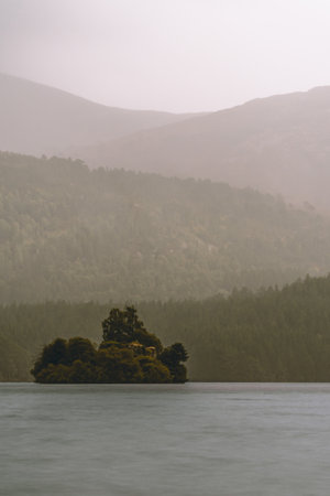 A fortress rises resolutely from the heart of a pristine lake, standing as a sentinel of history and strength. Surrounded by shimmering waters, this majestic stronghold commands attention, evoking a sense of intrigue and wonder as it stands steadfast in its watery domain.の写真素材