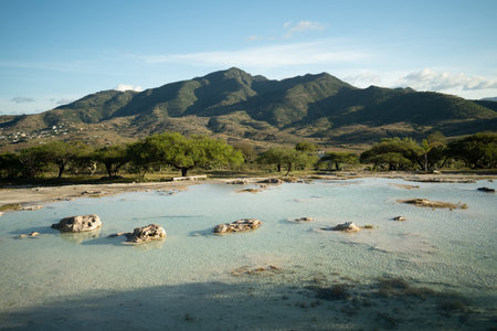 Oaxaca, Mexico, a small pond emerges, its shimmering surface formed by sulfur-rich thermal waters. A tranquil oasis where nature's chemistry creates a unique haven of relaxation and rejuvenationの写真素材