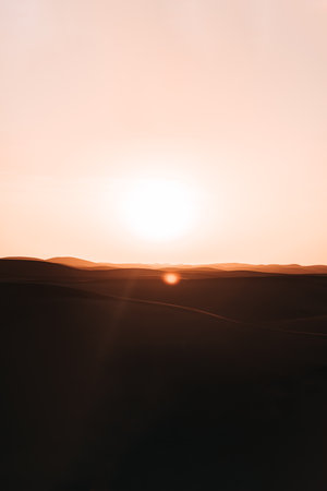 Sunset over the desert: A breathtaking display of golden hues transforms the landscape, evoking a sense of serenity and captivating beautyの写真素材
