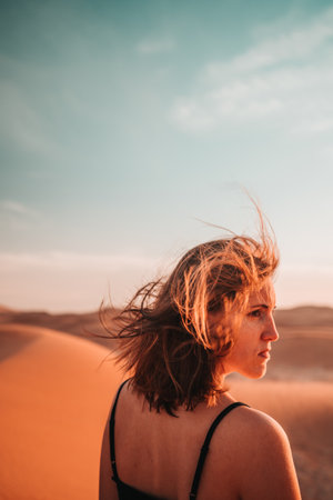Desert portrait: A woman's hair dances with the wind, embodying untamed beauty and a sense of enchantment amidst the barren expanse.の写真素材