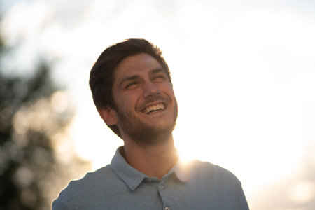 Portrait of a young man in a sunny day: Bathed in sunlight, revealing his youthful vibrancy and the radiant energy of the day.の写真素材