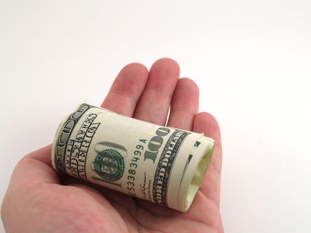 Roll of one hundred dollar bills held out in handの写真素材