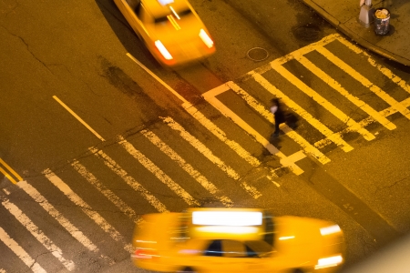 Crossing the Road between 2 taxisの写真素材