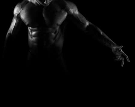 Silhouette of young athlete bodybuilder man on blackの写真素材