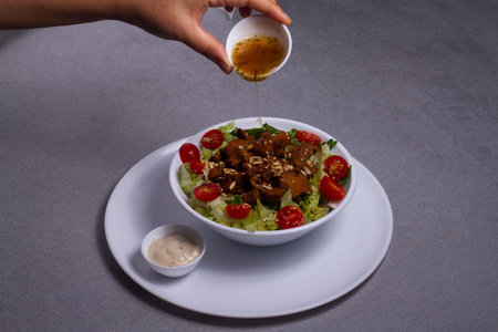 Bowl of traditional caesar salad with chicken and bacon isolated on gray backgroundの写真素材