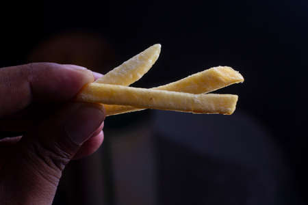 hand holding French fries potatoes isolated on white background