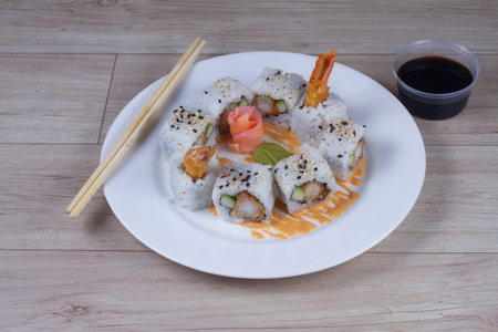 A set of sushi rolls with crab, Japanese omelette and cucumber on a plate with chopsticks.の写真素材
