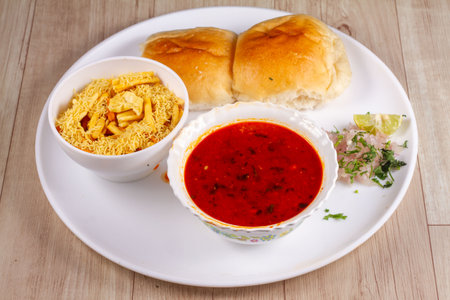 picy Misal Pav or usal Pav is a traditional snack or Chaat food from Maharashtra, India. Served with chopped onion, lemon wedges and farsan. Selective focusの写真素材