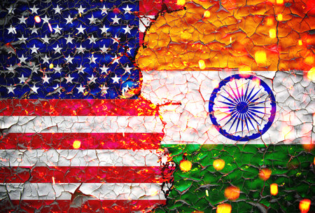 us and india flags painted over cracked concrete wall.And lava flows behind. us vs india tariff war.の写真素材